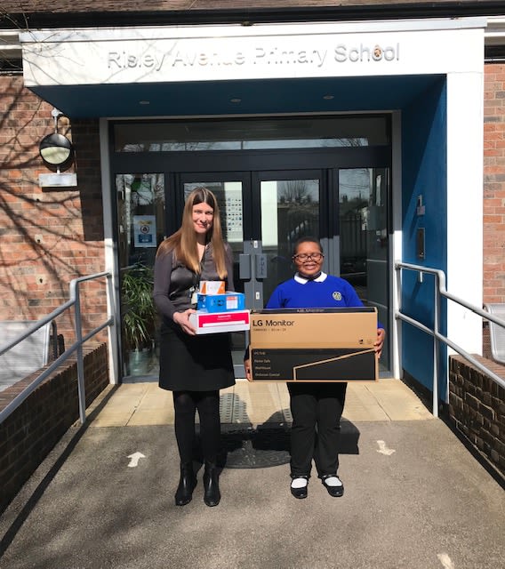 Pupil from Risley Avenue Primary School receiving a computer screen and peripherals donated by Raspberry Pi and The Bloomfield Trust